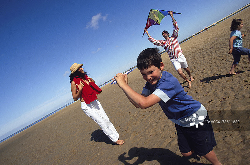 一家人一起在海滩放风筝图片素材