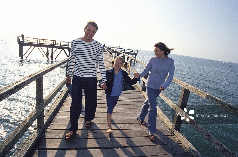 一家人一起沿着码头散步图片素材