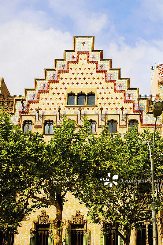 西班牙巴塞罗那，阿马特勒住宅，建筑前的树木图片素材