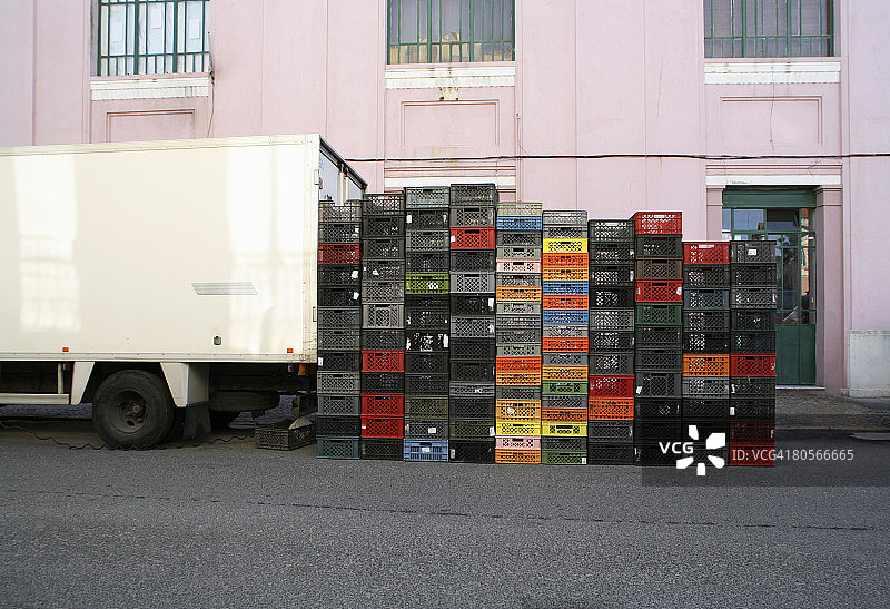 一堆板条箱在一辆运货车旁边图片素材