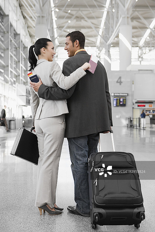 一个商人和一个女商人挽着对方站在机场图片素材