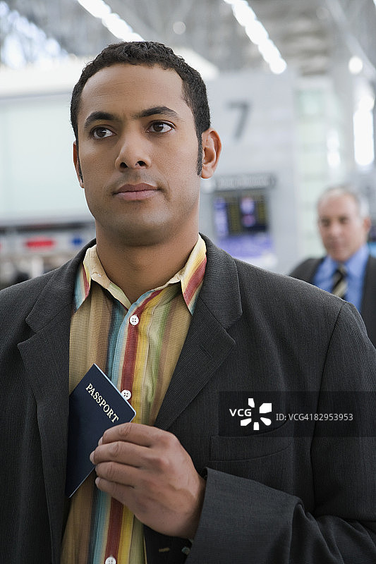 一个商人把护照放在他的外套口袋里的特写图片素材