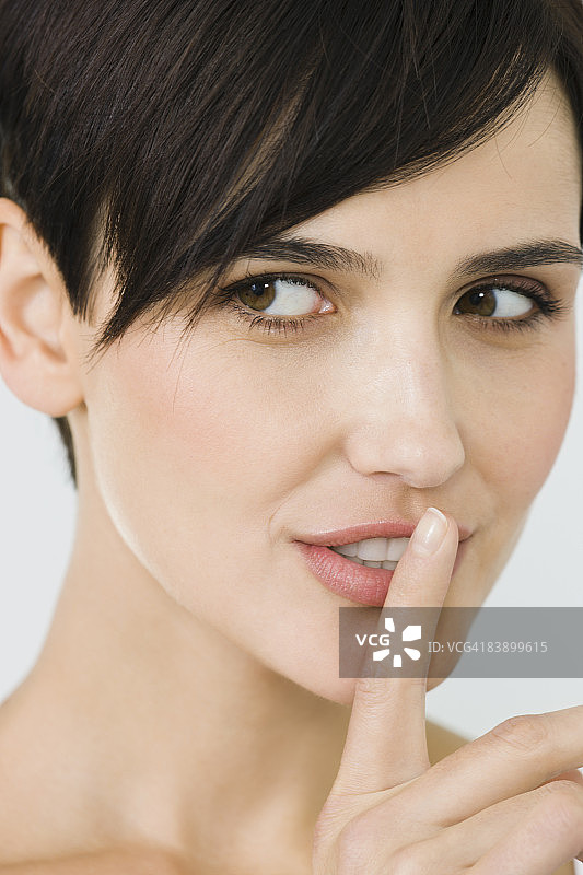 一个手指放在嘴唇上的女人，特写图片素材