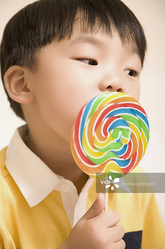 一个男孩吃棒棒糖的特写图片素材