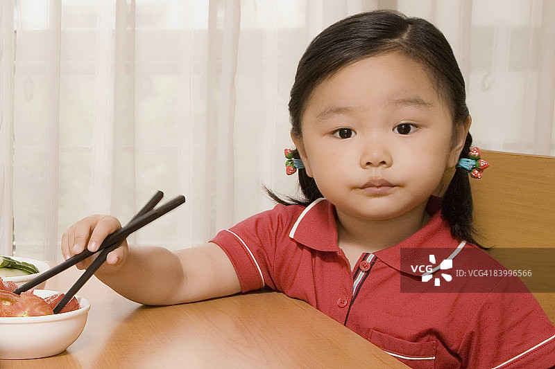 一个女孩用筷子吃沙拉的肖像图片素材