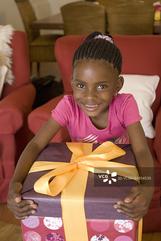 一个小女孩拿着生日礼物的肖像。约翰内斯堡，豪登省，南非图片素材
