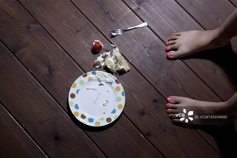 女孩把蛋糕掉在地板上图片素材