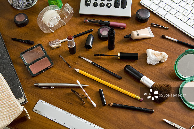 堆满化妆品和办公用品的办公桌图片素材