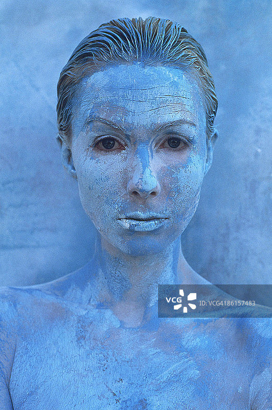 一个女人在一堵蓝色的墙前涂着蓝色图片素材