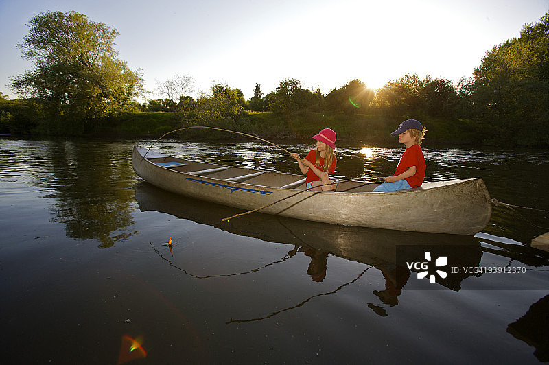 小女孩和男孩在钓鱼。图片素材