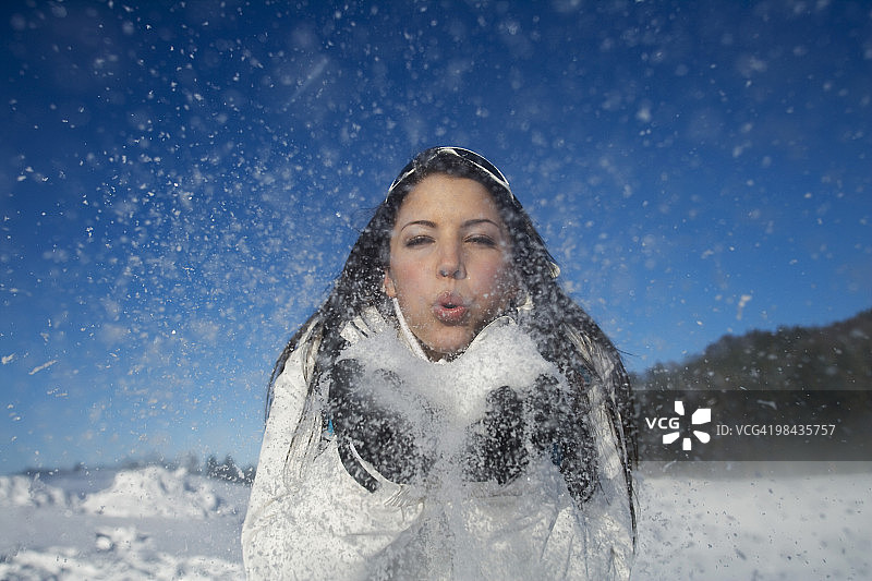年轻女子玩雪的肖像图片素材