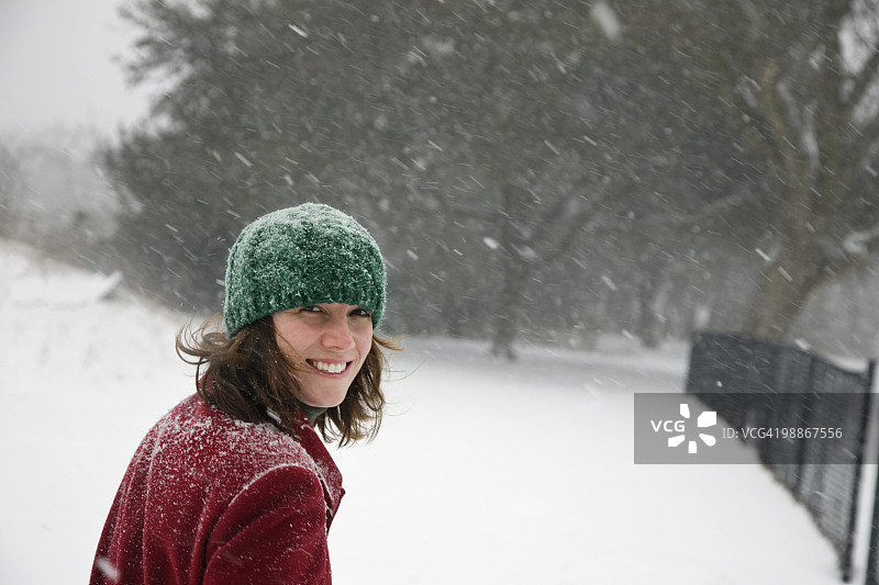 一个白人女人在暴风雪中行走图片素材