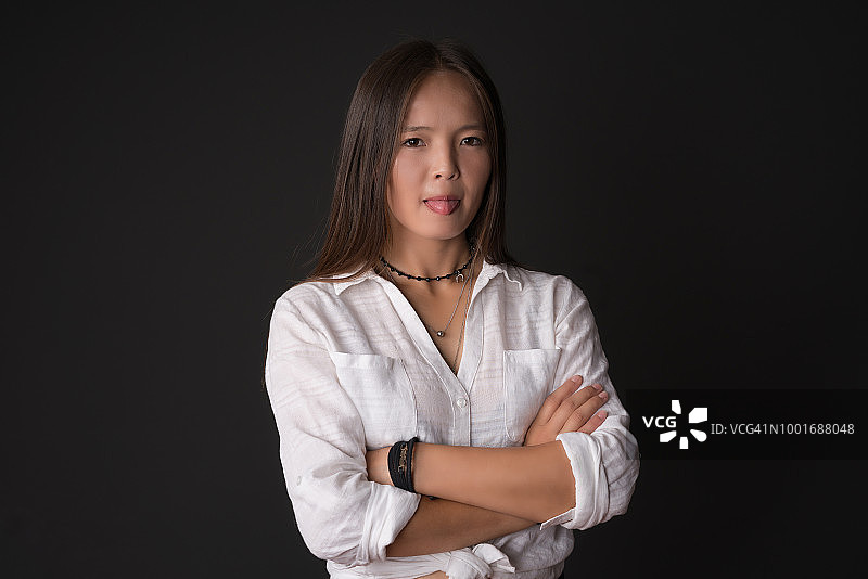 年轻的亚洲女人面部表情在黑色的背景图片素材