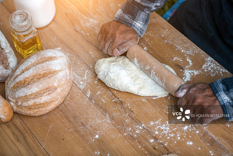 手揉生面团放在桌上平铺。顶视图在面包师的工作场所，工作与糕点，自由空间上的花桌子。烹饪、烹饪、烘焙概念图片素材