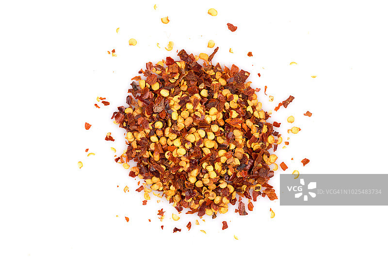 一堆压碎的红辣椒，干辣椒片和种子孤立在白色的背景上图片素材