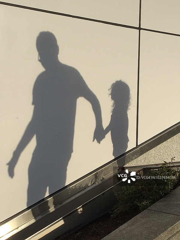 影子人物:一个男人和一个女孩在室外楼梯上图片素材