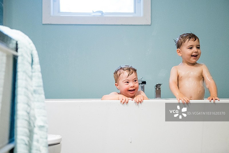 唐氏综合症的可爱男孩和他哥哥一起洗澡图片素材