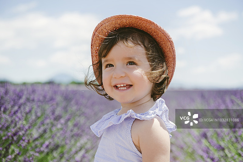 法国，普罗旺斯，瓦朗索高原，快乐的学步女孩在紫色薰衣草的田野在夏天图片素材