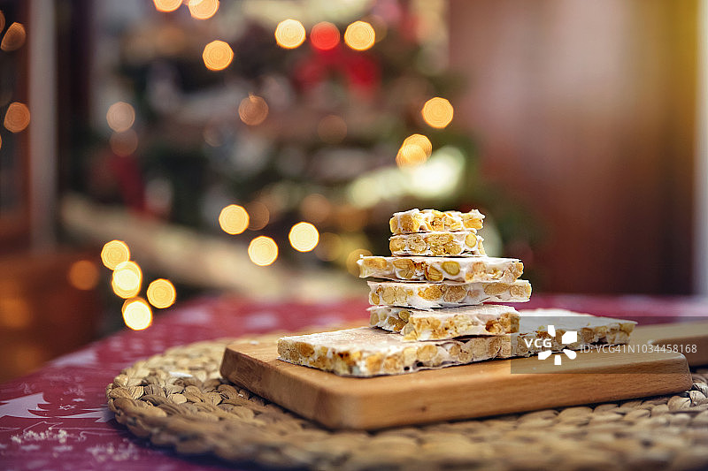 Turrón，杏仁牛轧糖，放在圣诞树旁边的木板上图片素材