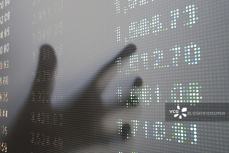 股票数据数字电子表格在大LED屏幕与手在后台图片素材