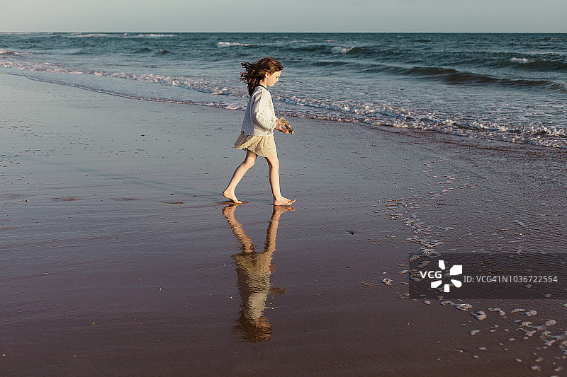 西班牙，海滩上的女孩走向大海图片素材