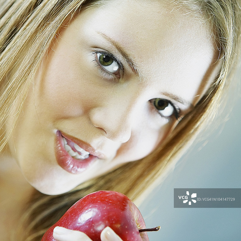 一个拿着苹果的年轻女子的画像图片素材