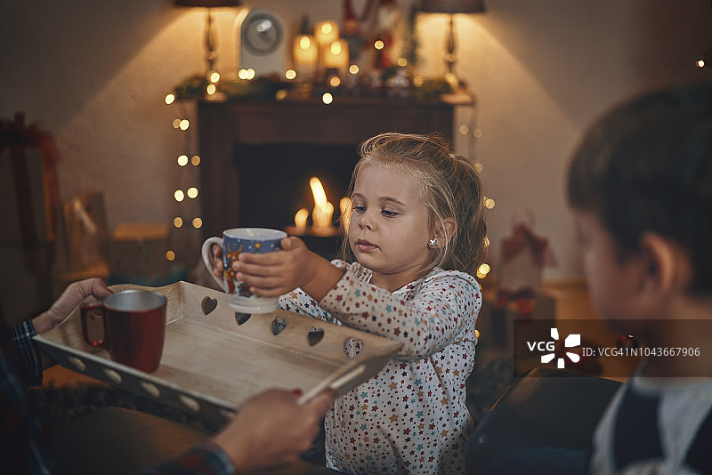 穿着睡衣和圣诞袜的可爱的孩子们在圣诞节喝着热巧克力和棉花糖图片素材