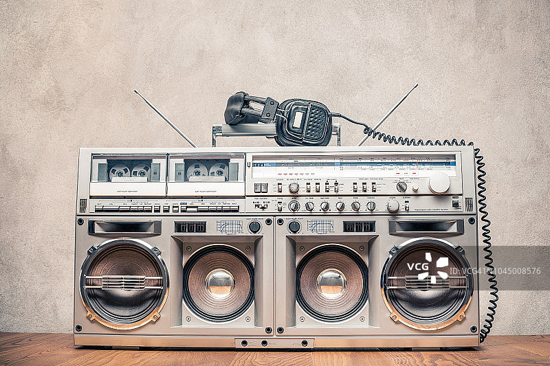 复古的旧贫民窟爆破立体声收音机盒式磁带录音机立体声从大约80年代和耳机前混凝土墙背景。复古instagram风格过滤照片图片素材