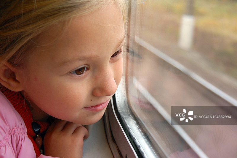 小女孩从火车窗口往外看图片素材