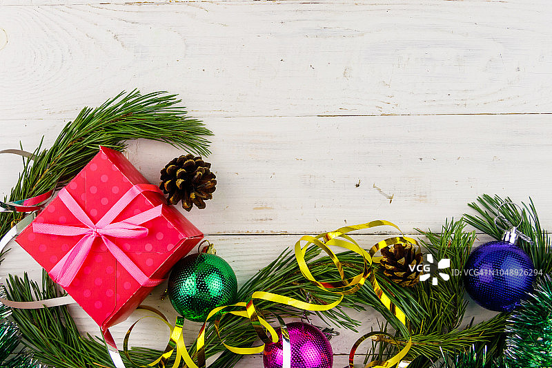 用冷杉树枝、礼物盒和圣诞装饰品组成的圣诞作文在白色的木制桌子上。俯视图，复制空间图片素材