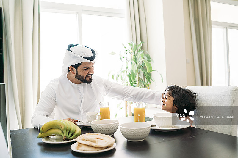 一个阿拉伯人在家里和儿子吃早餐图片素材