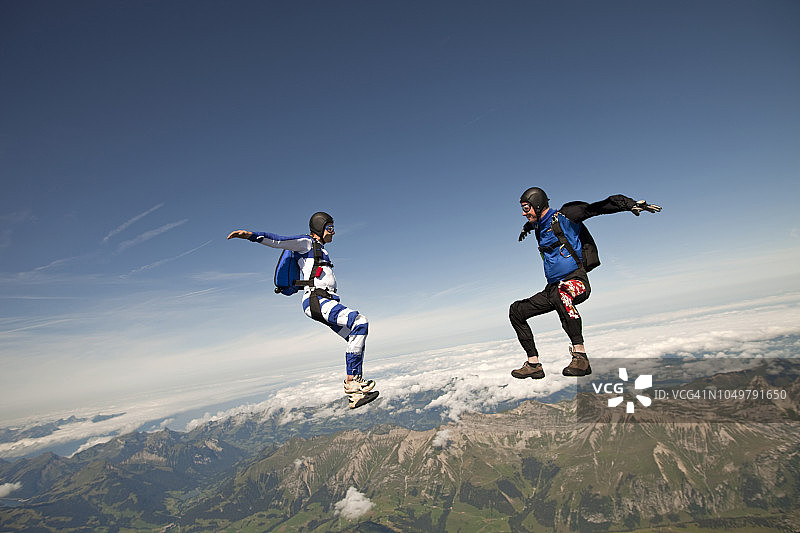 跳伞者从高山之上的高空中俯冲而下图片素材