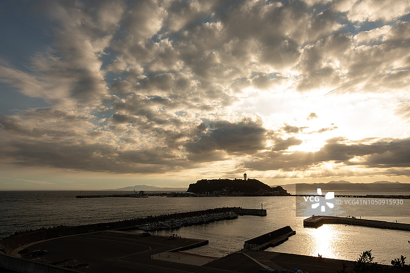 在日本神奈川县的Enoshima，相模湾和箱根山的橙色日落阳光图片素材