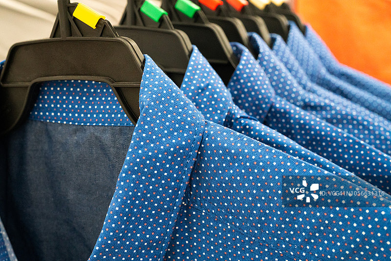 男布，衣柜衣架上挂着一排蓝色男式衬衫图片素材