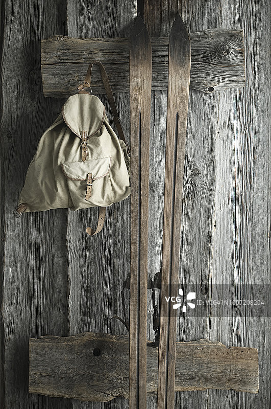 木制的滑雪板和旧背包挂在质朴的木墙上图片素材