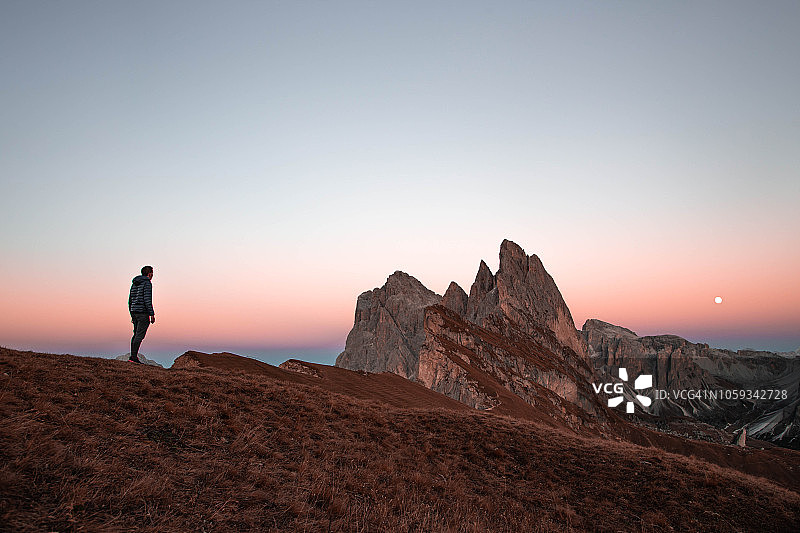 盖伊在黄昏时分发现美丽的白云石山在Seceda山的山顶。图片素材
