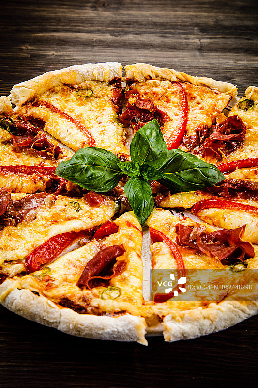 玛格丽塔披萨，火腿和胡椒，木质背景图片素材