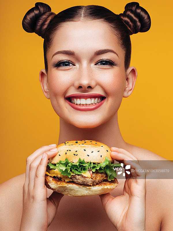 微笑的年轻女人拿着汉堡图片素材