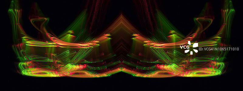 近距离抽象图案交织的彩色光束的颜色绿色，红色和橙色的运动在黑色的背景。图片素材