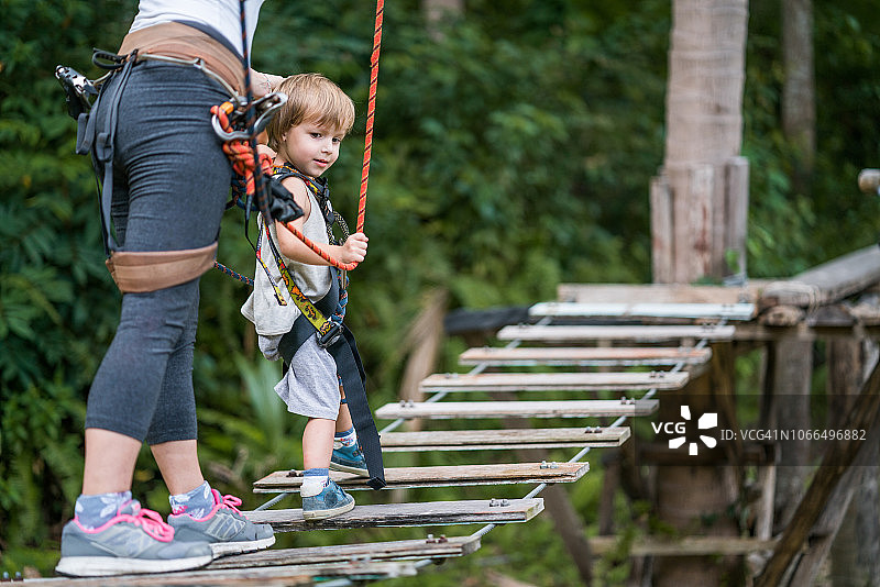 一个小男孩和他的妈妈在大自然的林冠之旅中行走。图片素材