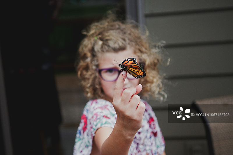 女孩拿出一只帝王蝶对着镜头图片素材