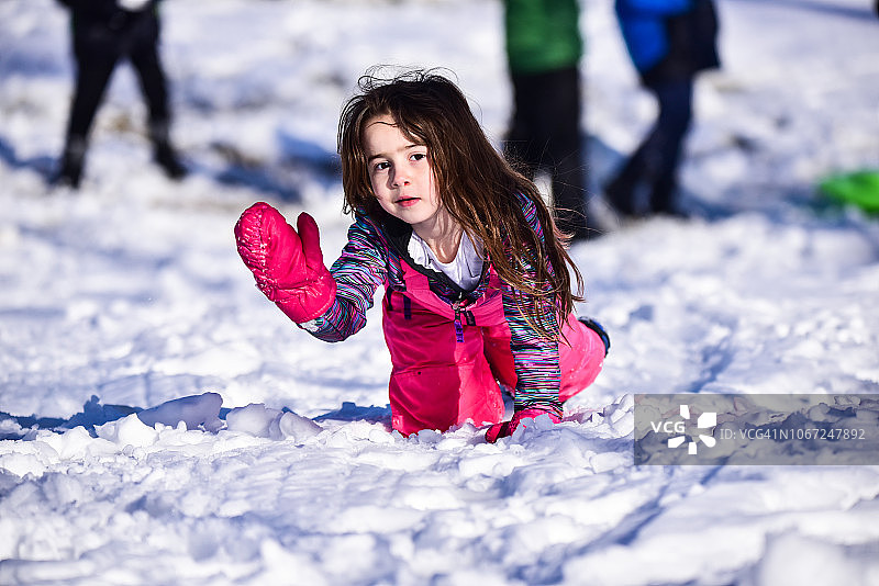 一个小女孩在外面的雪地里。图片素材