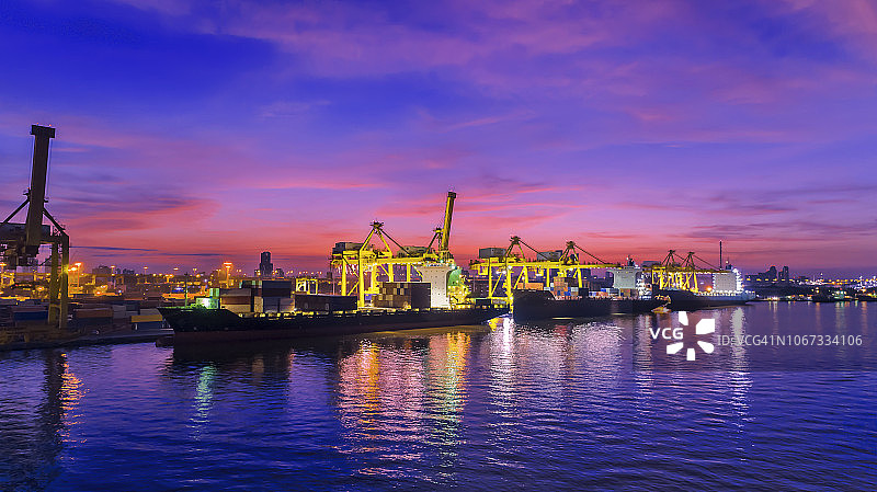 黄昏时分，泰国码头上的集装箱起重机正在吊装集装箱。图片素材