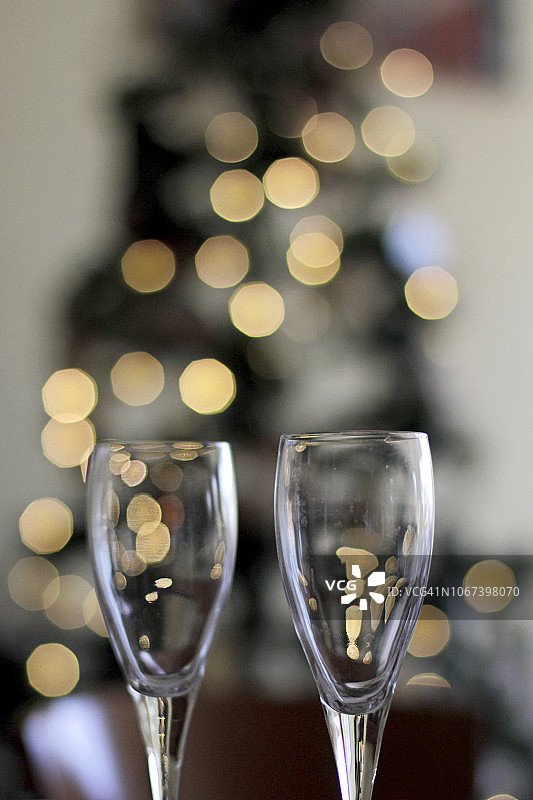 在模糊的圣诞树前喝两杯香槟。图片素材