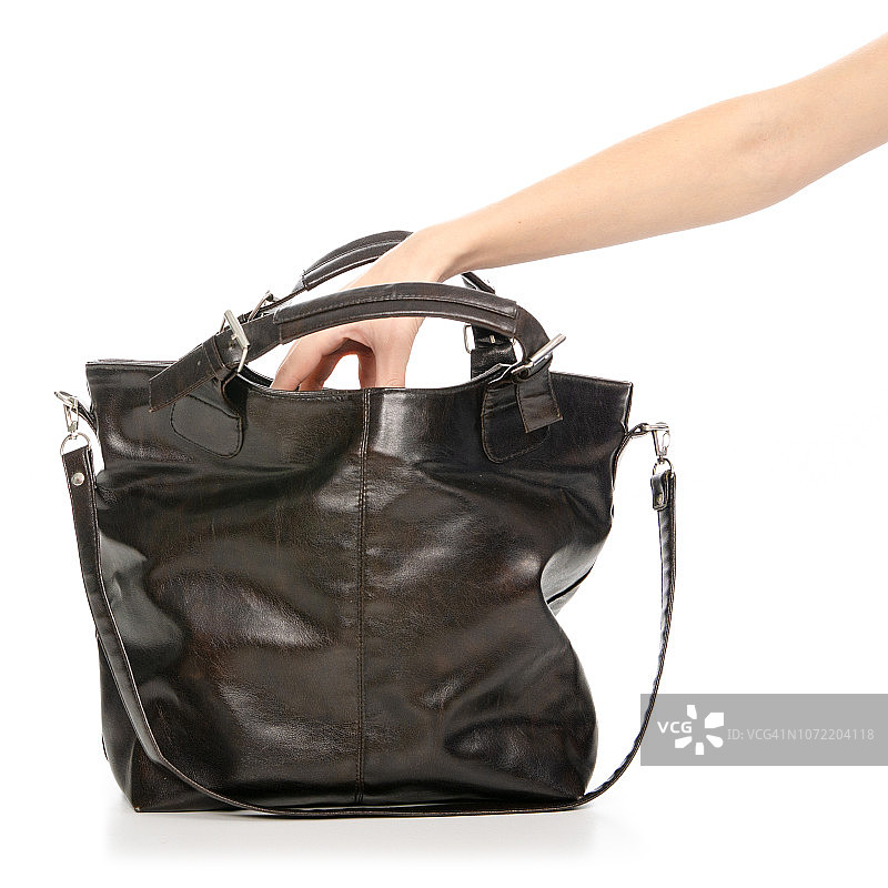 女人手里的黑色棕色的女式皮包从包里抽出来图片素材