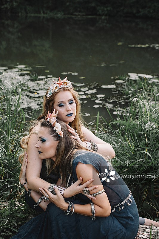 两个波西米亚女人坐在湖边，俄罗斯图片素材