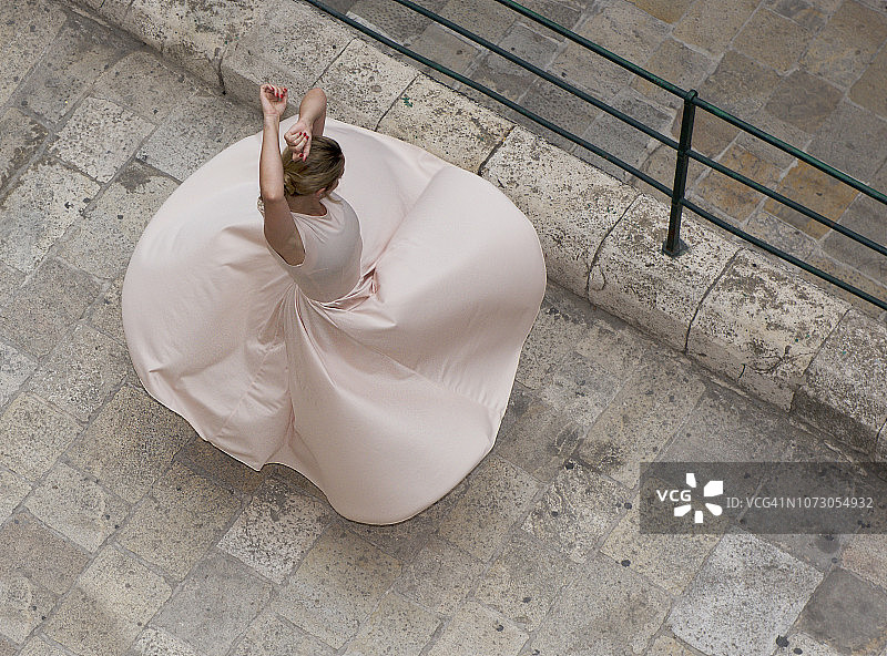 一个女人在街上跳舞的头顶视图，瓦莱塔，马耳他图片素材