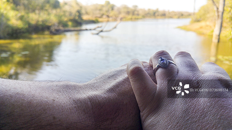 一对白人夫妇在南非克鲁格国家公园的水边庆祝订婚图片素材