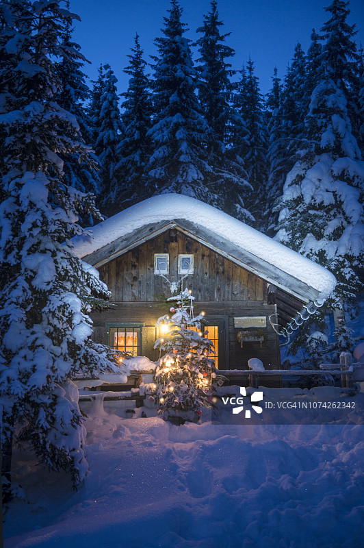 奥地利，Altenmarkt-Zauchensee，圣诞树上的装饰木屋在晚上的雪图片素材