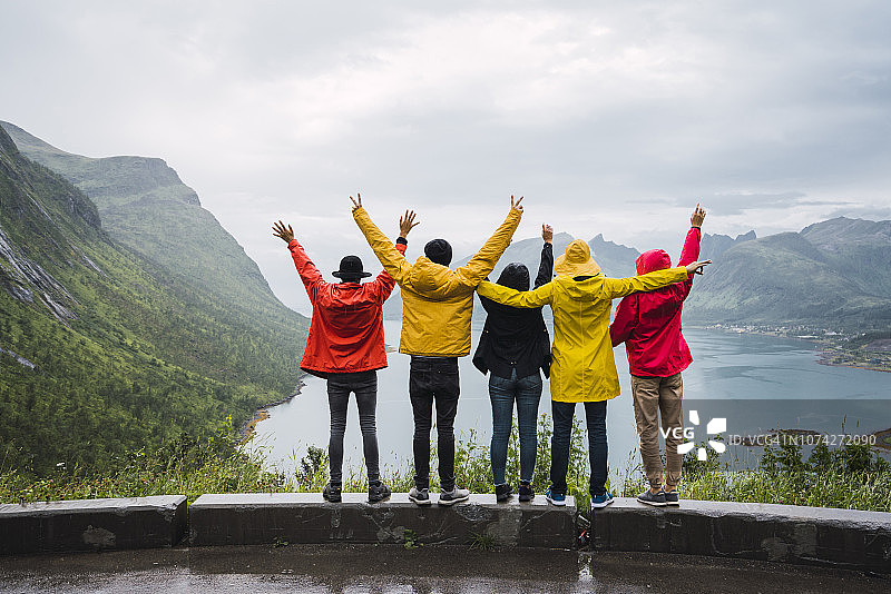 挪威，Senja岛，后视图欢呼的朋友站在一个观测点的海岸图片素材